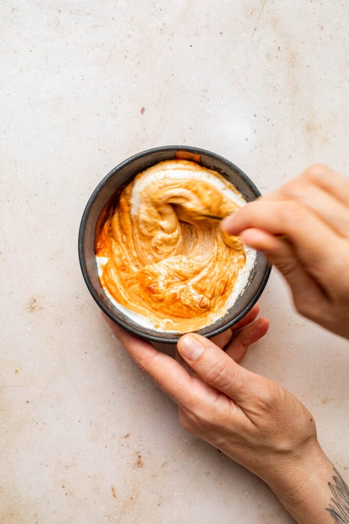 hand mixing spicy mayo