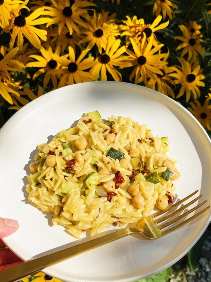 plate of zucchini orzo and flowers