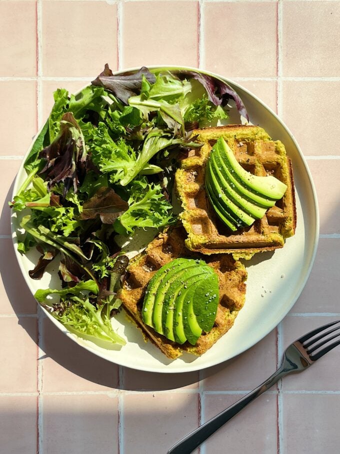 waffles with avocado and salad on plate