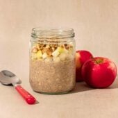 jar of apple pie overnight oats with spoon and apples