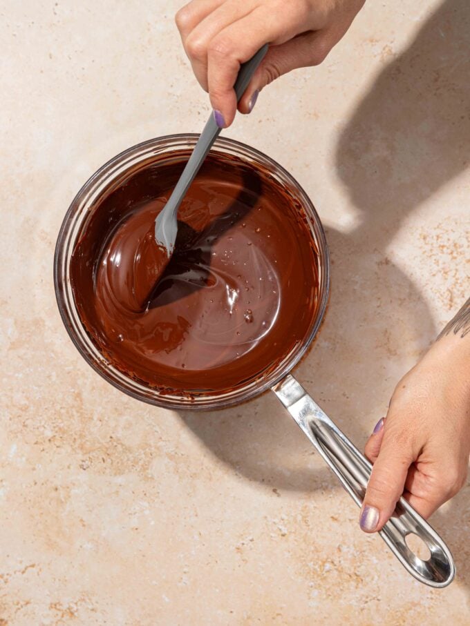 hand stirring chocolate in pot