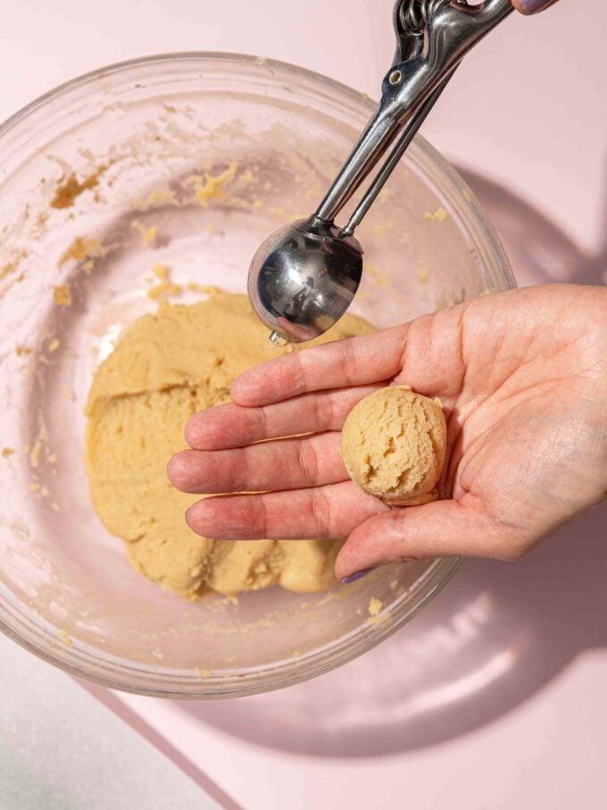hand scooping thumbprint cookies