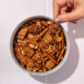hand with bowl of chex mix